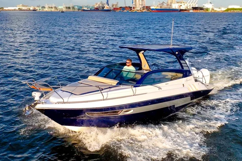 Custom Order Your 305 Today! Yacht Photos Pics 2025 Hanover 305 Outboard cruising on open water with cityscape background.