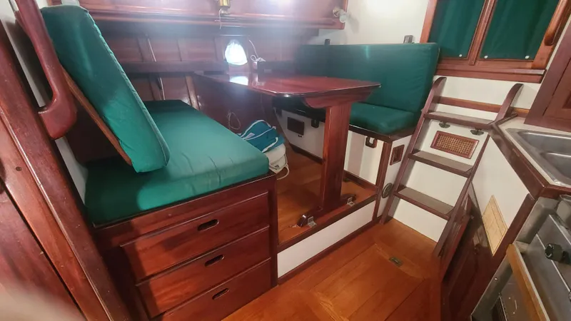 Chantey II Yacht Photos Pics Interior of 1989 Covey Island 48 Motorsailor with wooden furnishings and green cushions.