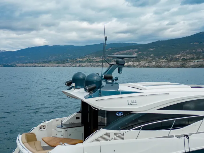 Lakehouse Yacht Photos Pics 2016 Sea Ray L590 yacht on a serene lake with mountainous backdrop.