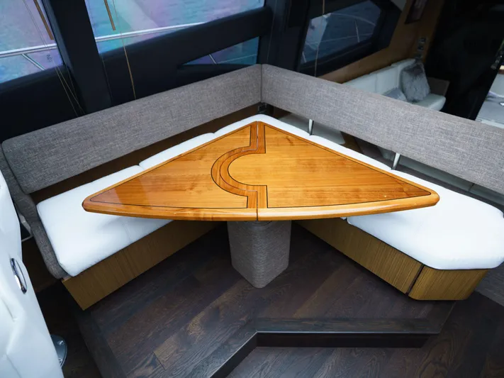 Lakehouse Yacht Photos Pics 2016 Sea Ray L590 yacht interior with triangular wooden table and cushioned seating.