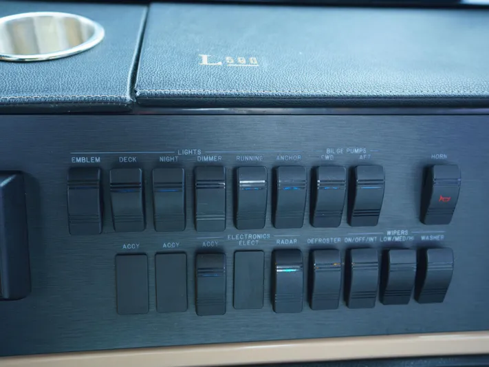 Lakehouse Yacht Photos Pics Control panel of a 2016 Sea Ray L590 yacht with labeled switches and cup holder.