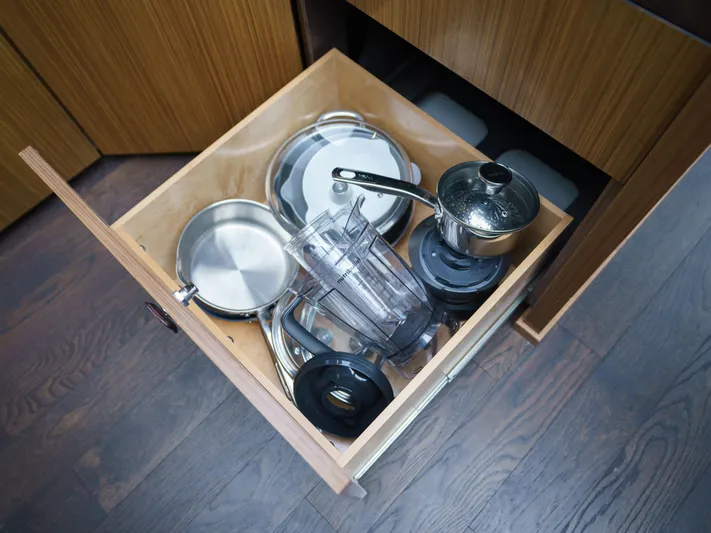 Lakehouse Yacht Photos Pics Open kitchen drawer with pots, pans, and blender parts on a Sea Ray L590 yacht.