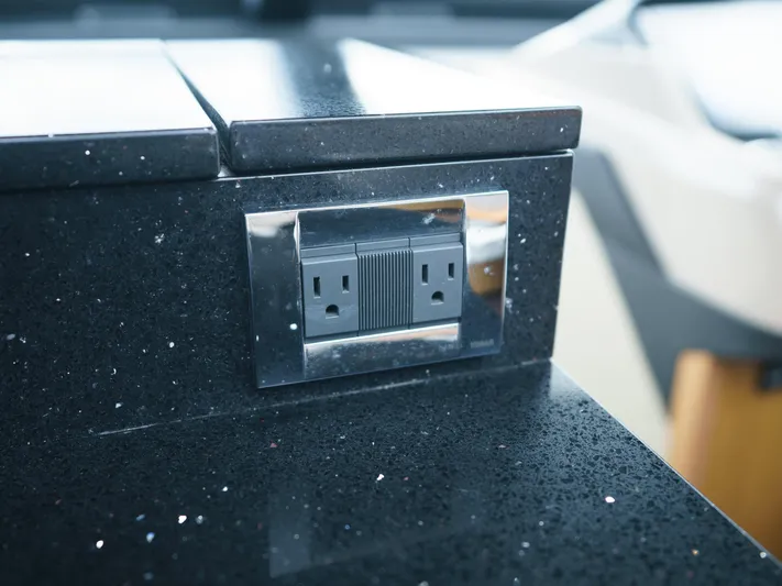 Lakehouse Yacht Photos Pics Power outlet on black countertop in 2016 Sea Ray L590 yacht interior.