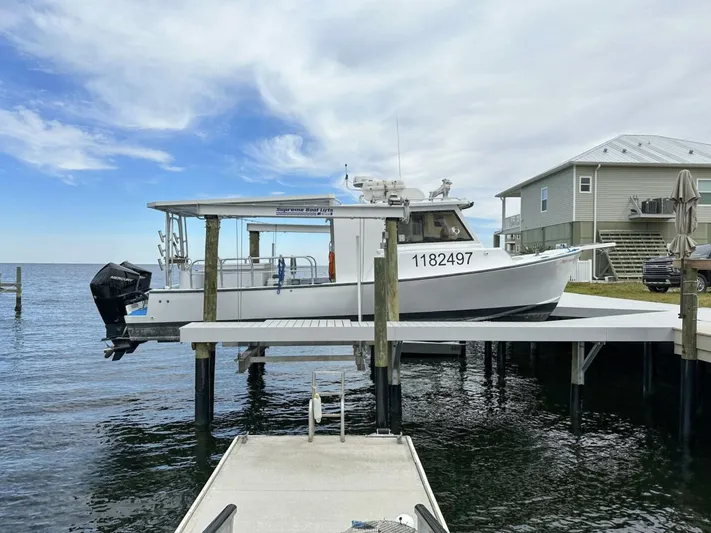  Yacht Photos Pics Crusader Boats 34, 1993 model, docked on a lift by waterfront home.
