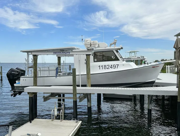  Yacht Photos Pics 1993 Crusader Boats 34 docked, featuring a white hull and outboard motor, under a clear sky.