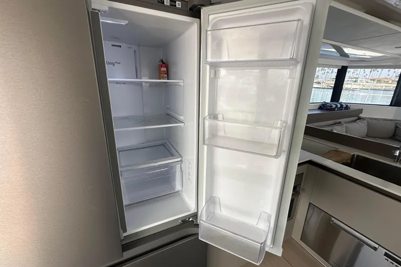 Hamlet Yacht Photos Pics Open refrigerator in Leopard 46PC yacht, showcasing spacious interior and modern kitchen setting.