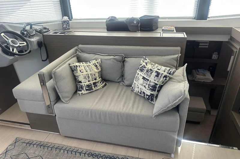Hamlet Yacht Photos Pics Modern interior of 2023 Leopard 46PC yacht with cozy gray sofa and patterned cushions.
