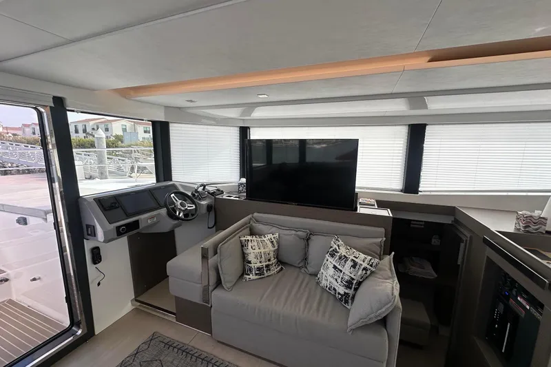 Hamlet Yacht Photos Pics Interior of 2023 Leopard 46PC yacht with helm, sofa, and large windows.
