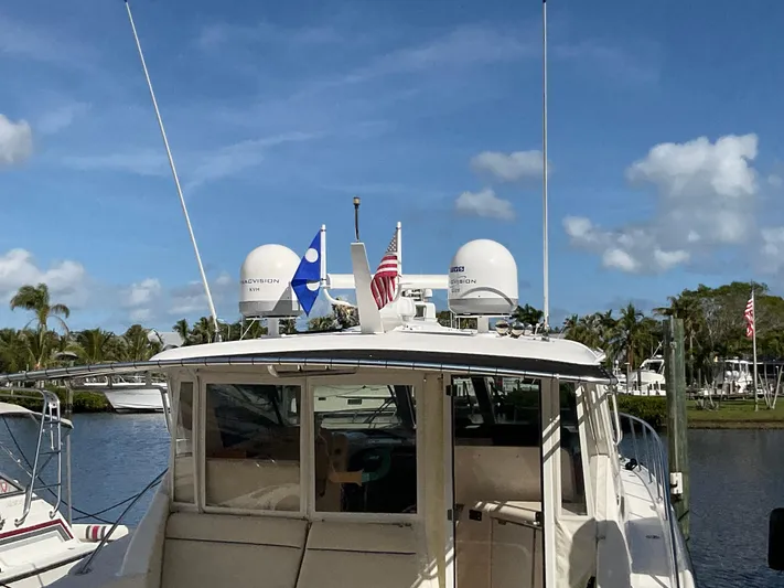 Cc Rider Yacht Photos Pics 2004 Tiara Yachts 4400 Sovran docked, featuring radar domes and flags under a clear sky.