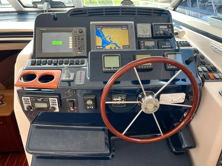 Cc Rider Yacht Photos Pics Helm of 2004 Tiara Yachts 4400 Sovran with navigation equipment and wooden steering wheel.