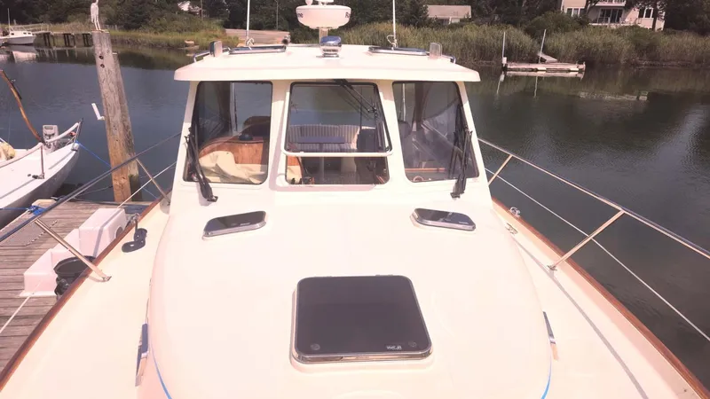 Odyssey III Yacht Photos Pics 2008 Legacy 32 boat docked by a serene waterfront.