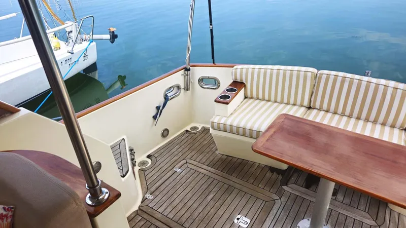 Odyssey III Yacht Photos Pics Luxurious 2008 Legacy 32 yacht interior with striped seating and wooden table.