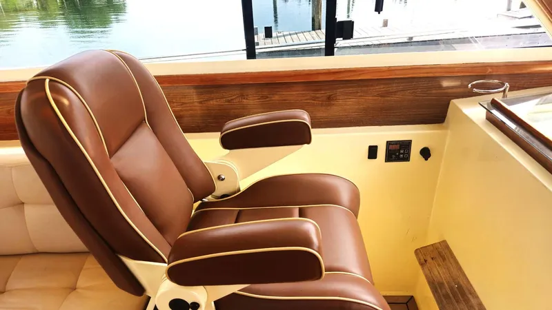 Odyssey III Yacht Photos Pics Luxurious brown leather captain's chair on 2008 Legacy 32 yacht, near water.