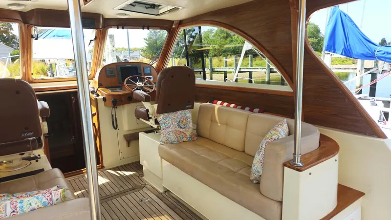 Odyssey III Yacht Photos Pics Interior of a 2008 Legacy 32 boat with beige seating and wooden accents.