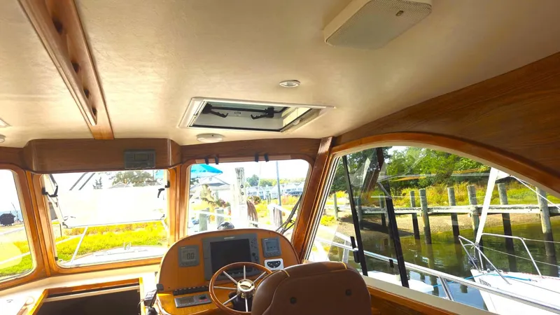 Odyssey III Yacht Photos Pics Interior view of 2008 Legacy 32 boat, featuring helm and wooden accents.