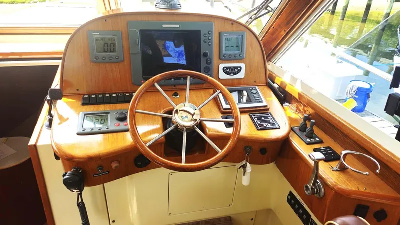 Odyssey III Yacht Photos Pics Helm of 2008 Legacy 32 boat with wooden steering wheel and navigation instruments.