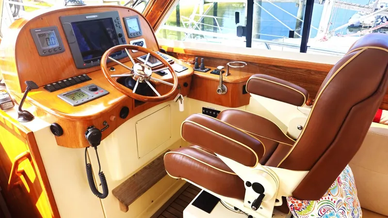 Odyssey III Yacht Photos Pics Helm of 2008 Legacy 32 boat with steering wheel and navigation equipment.
