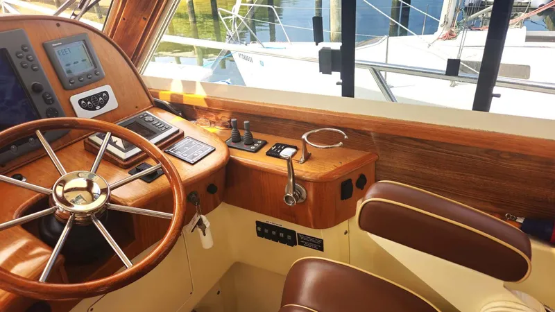 Odyssey III Yacht Photos Pics Helm of 2008 Legacy 32 boat with wooden steering wheel and navigation controls.