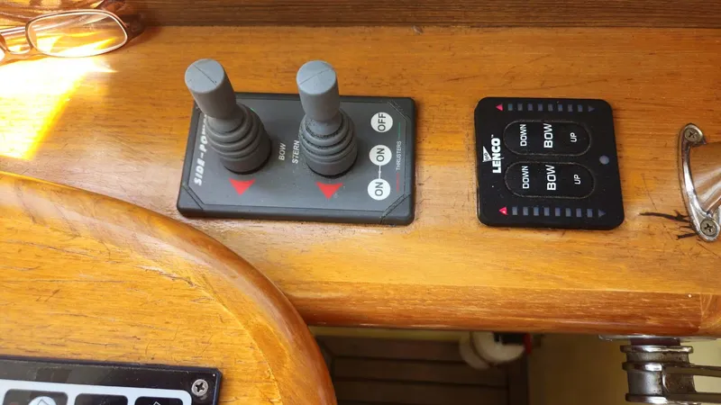 Odyssey III Yacht Photos Pics Boat control panel with joysticks and switches on a wooden surface, Legacy 32, 2008 model.