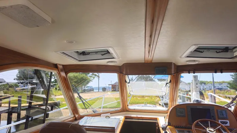 Odyssey III Yacht Photos Pics Interior view of 2008 Legacy 32 boat with wooden accents and navigational equipment.