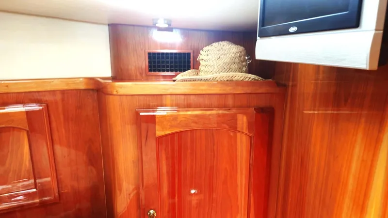 Odyssey III Yacht Photos Pics Interior of 2008 Legacy 32 boat with wooden cabinetry and a straw hat.