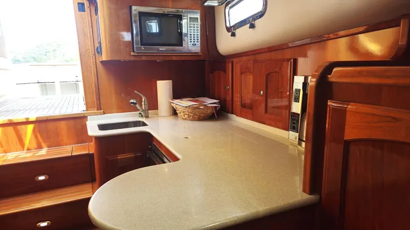 Odyssey III Yacht Photos Pics 2008 Legacy 32 yacht kitchen with wooden cabinetry, microwave, and countertop.