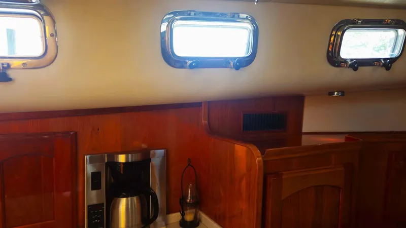 Odyssey III Yacht Photos Pics Interior of 2008 Legacy 32 boat with wooden cabinetry and coffee maker.