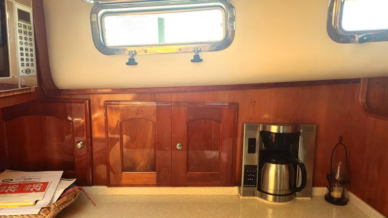 Odyssey III Yacht Photos Pics Interior of a 2008 Legacy 32 boat with wooden cabinets and a coffee maker.