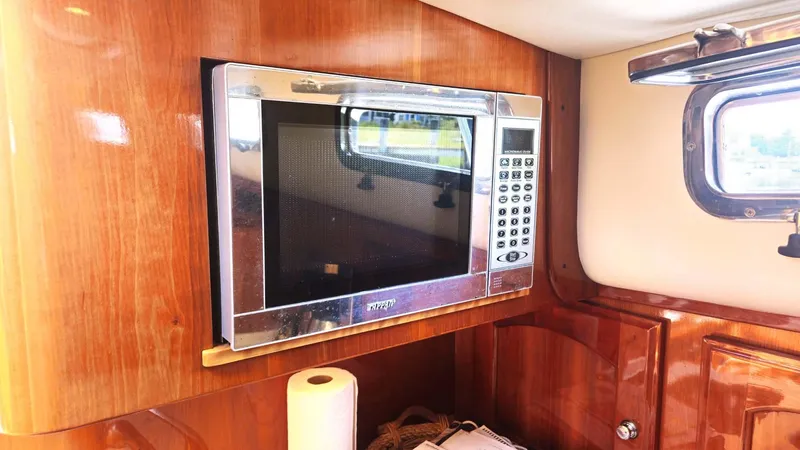 Odyssey III Yacht Photos Pics Microwave in 2008 Legacy 32 boat interior with wooden cabinetry and window.