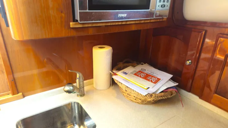 Odyssey III Yacht Photos Pics Kitchen area in a 2008 Legacy 32 boat with sink, microwave, and paper towel holder.