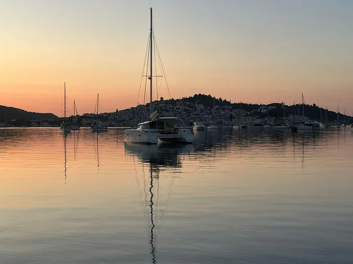  Yacht Photos Pics Sunset over calm harbor with Fountaine Pajot Lipari 41 catamaran, 2011 model, reflecting on water.