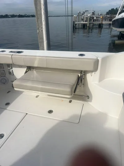  Yacht Photos Pics 2016 Boston Whaler 315 Conquest boat interior with foldable seat by the water.