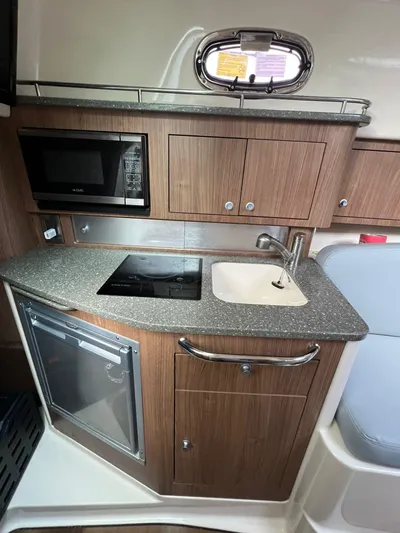  Yacht Photos Pics 2016 Boston Whaler 315 Conquest galley with microwave, sink, and storage cabinets.
