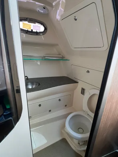  Yacht Photos Pics 2016 Boston Whaler 315 Conquest boat bathroom with sink, toilet, and storage cabinets.
