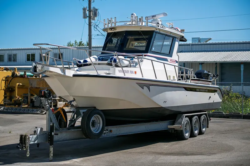  Yacht Photos Pics 1990 Boston Whaler 31 Offshore Custom Conquest on trailer, parked outdoors.