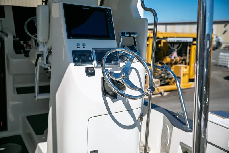  Yacht Photos Pics 1990 Boston Whaler 31 Offshore Custom Conquest helm with steering wheel and navigation equipment.