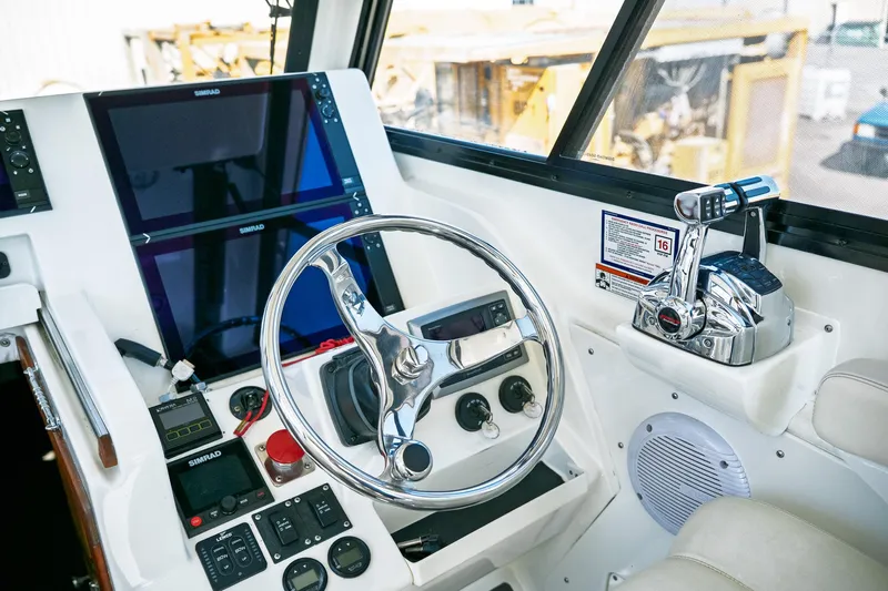  Yacht Photos Pics Control panel of 1990 Boston Whaler 31 Offshore Custom Conquest with steering wheel and navigation screens.
