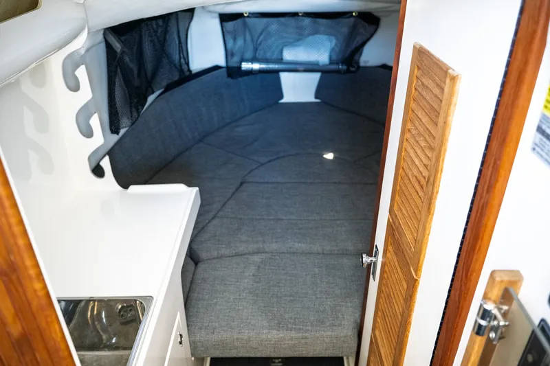  Yacht Photos Pics 1990 Boston Whaler 31 Offshore Custom Conquest cabin interior with gray seating and wooden accents.