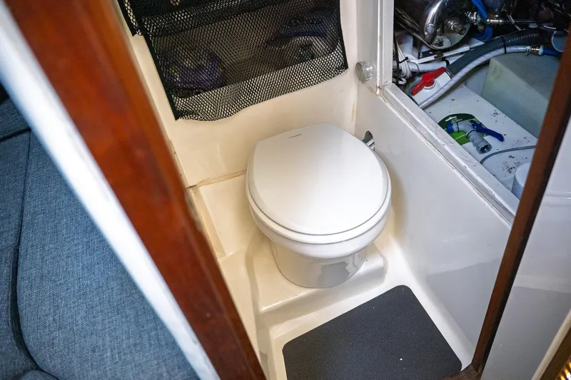  Yacht Photos Pics 1990 Boston Whaler 31 Offshore Custom Conquest boat interior with toilet and storage area.