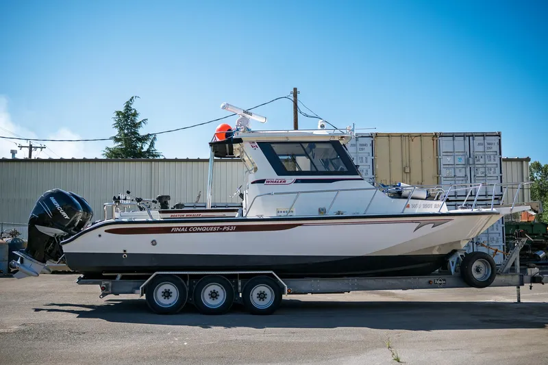  Yacht Photos Pics 1990 Boston Whaler 31 Offshore Custom Conquest boat on trailer, parked outdoors.