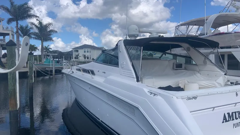 Amusement Yacht Photos Pics Sea Ray 500 Sundancer 1994 yacht docked at marina under cloudy sky.