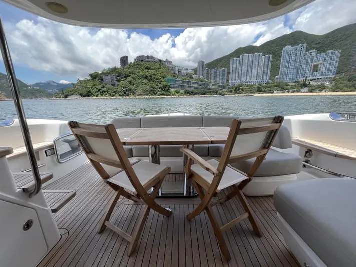  Yacht Photos Pics Luxury yacht Princess F45 deck with scenic coastal view, featuring comfortable seating and wooden flooring.
