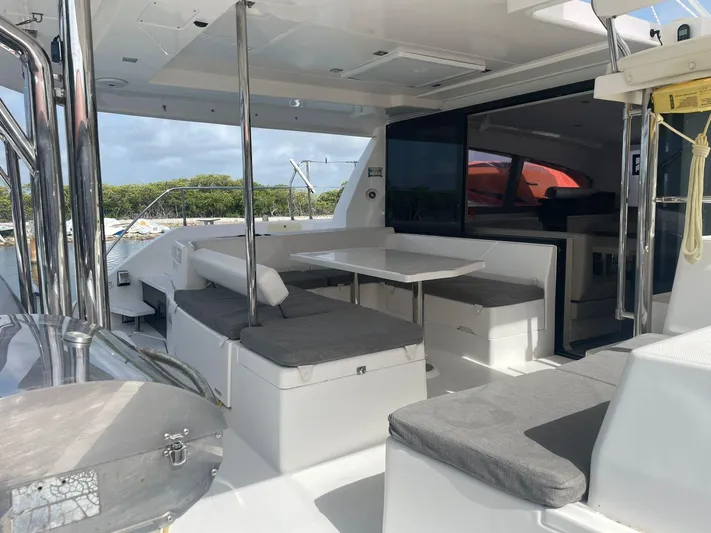 Morning Star Yacht Photos Pics Spacious deck of 2021 Leopard 40 catamaran with seating and table, docked by the water.