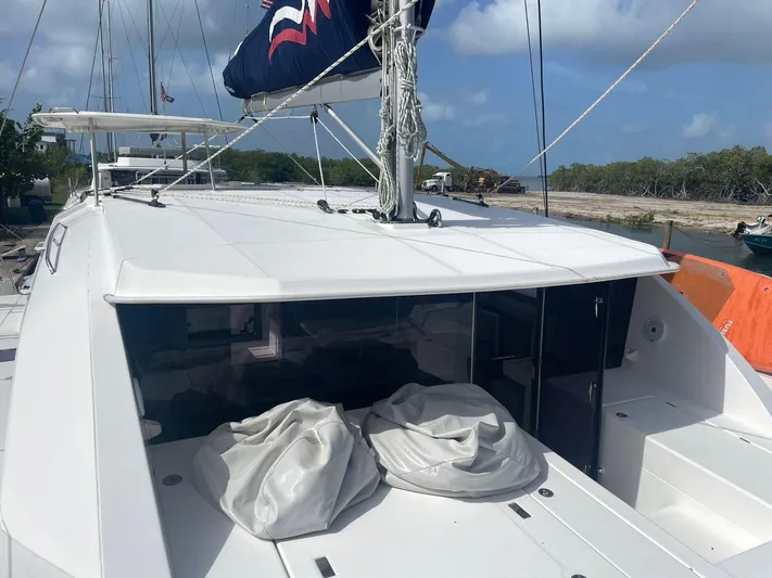 Morning Star Yacht Photos Pics 2021 Leopard 40 catamaran with sails, docked near a scenic shoreline.