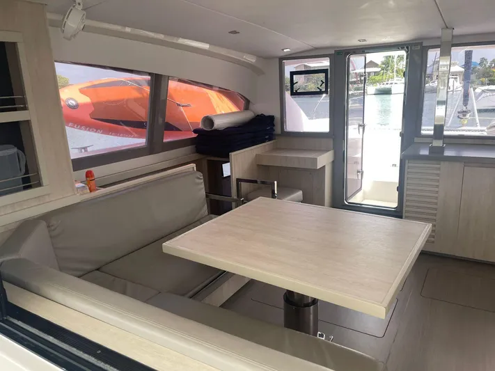 Morning Star Yacht Photos Pics Interior of 2021 Leopard 40 catamaran with modern seating and table, docked by the water.