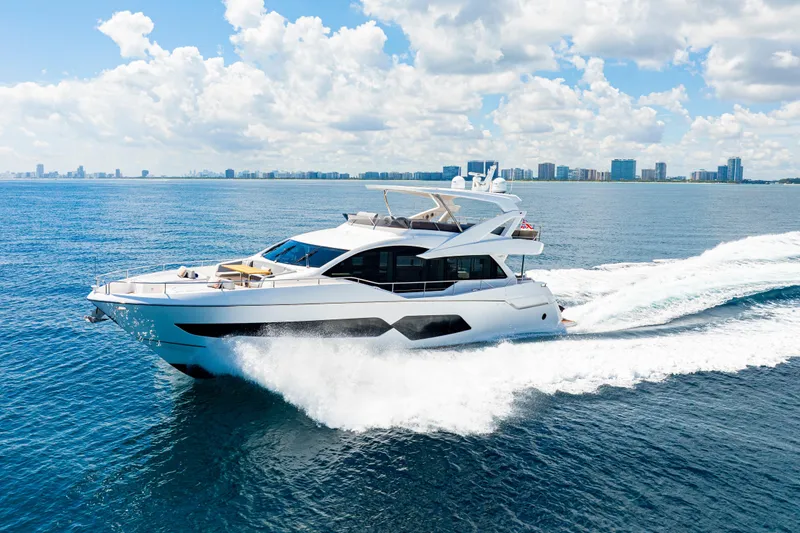  Yacht Photos Pics 2021 Sunseeker 76 Yacht cruising on open water under a bright blue sky.