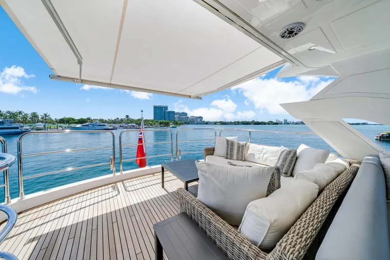  Yacht Photos Pics Luxurious Sunseeker 76 Yacht 2021 with elegant deck seating and scenic waterfront view.