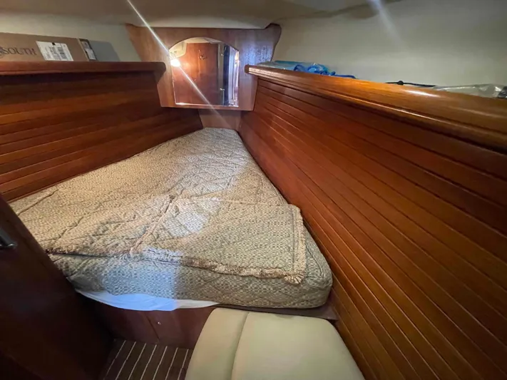 Sapphire Seas Yacht Photos Pics Cozy cabin interior of 2006 Hunter 45 Center Cockpit sailboat with wooden paneling and bed.