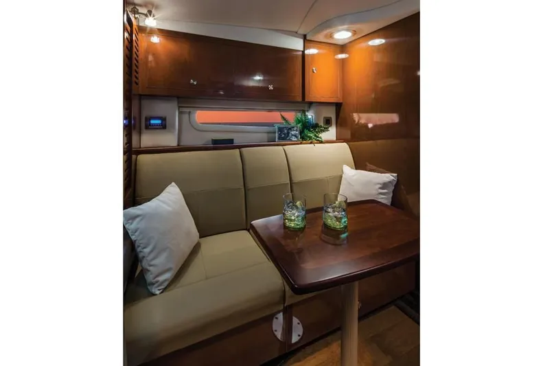 Luna Sea Yacht Photos Pics Interior of 2015 Sea Ray 310 Sundancer with cozy seating and wooden table.