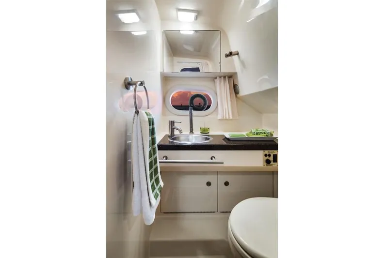 Luna Sea Yacht Photos Pics 2015 Sea Ray 310 Sundancer bathroom with sink, mirror, and towel.